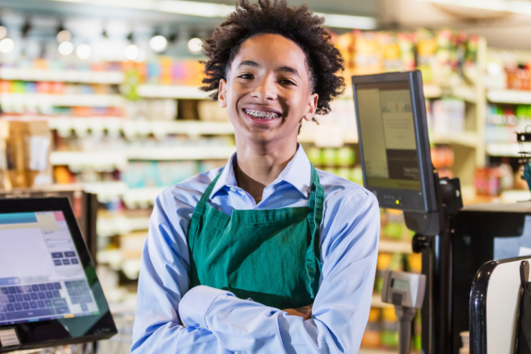 young person smiling working at a register